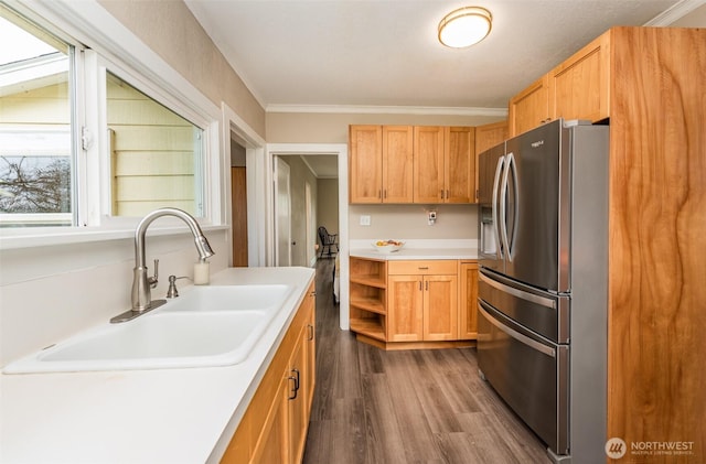 kitchen featuring crown molding, dark wood-type flooring, light countertops, stainless steel refrigerator with ice dispenser, and a sink