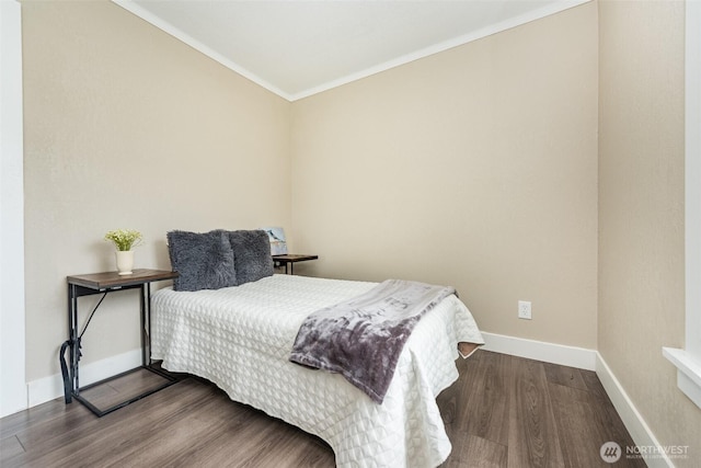 bedroom with baseboards, wood finished floors, and ornamental molding