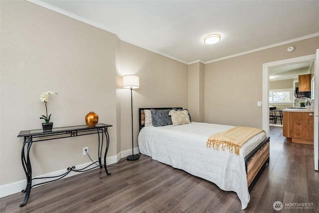 bedroom featuring a sink, baseboards, dark wood-type flooring, and crown molding