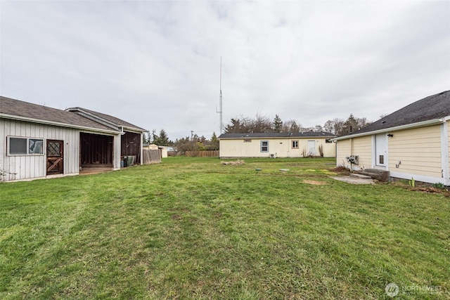 view of yard featuring an outbuilding, entry steps, and fence