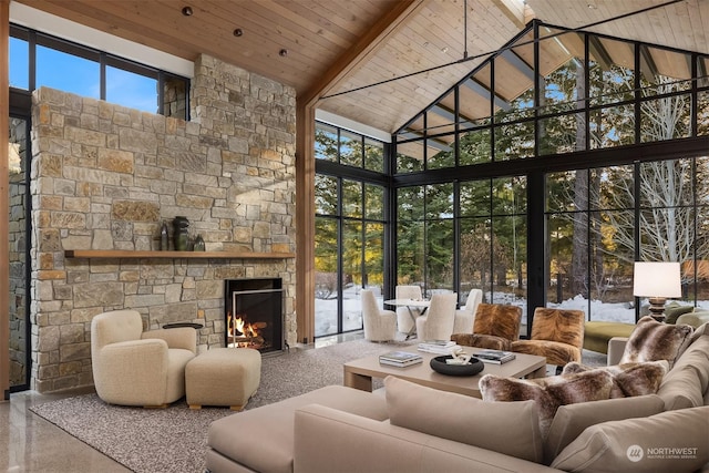 sunroom featuring wood ceiling, a stone fireplace, and lofted ceiling with beams