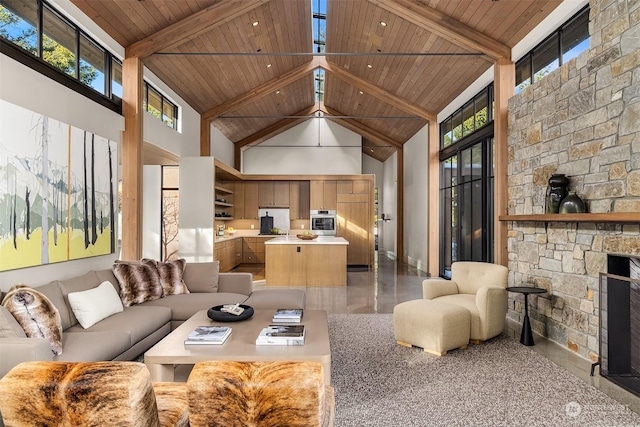 living room featuring beam ceiling, wood ceiling, high vaulted ceiling, and a fireplace