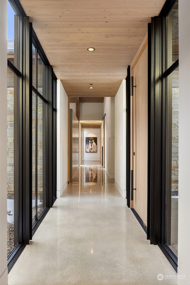 hallway featuring floor to ceiling windows and wood ceiling