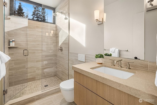 bathroom with vanity, toilet, an enclosed shower, and tile walls