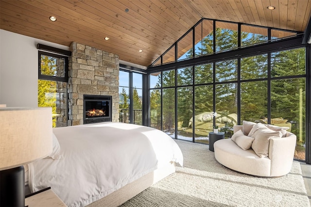 bedroom featuring high vaulted ceiling, a fireplace, wooden ceiling, and floor to ceiling windows