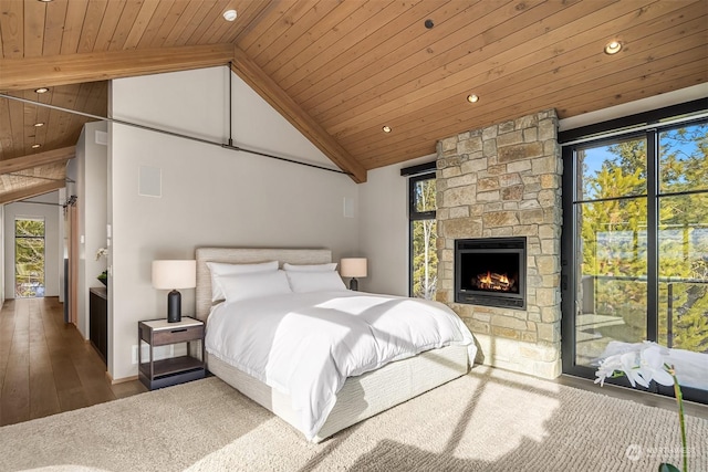 bedroom with wood ceiling, a stone fireplace, high vaulted ceiling, and hardwood / wood-style flooring