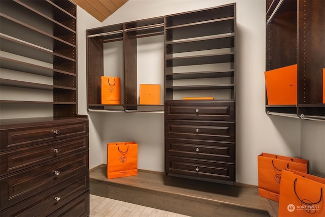 walk in closet with lofted ceiling and light hardwood / wood-style flooring