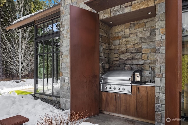 snow covered property entrance featuring exterior kitchen