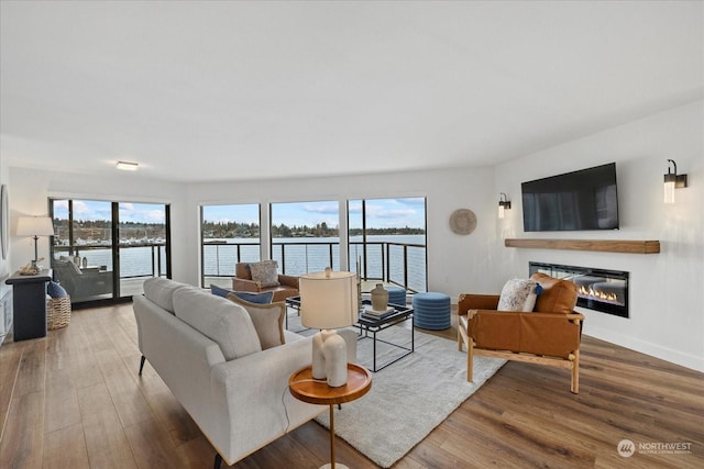 living room featuring a water view, a healthy amount of sunlight, and hardwood / wood-style flooring