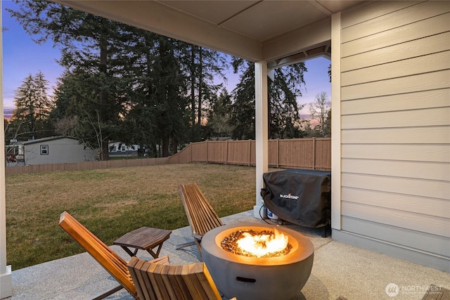 yard at dusk with an outdoor fire pit and a patio area