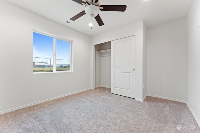 unfurnished bedroom with light carpet, a closet, and ceiling fan