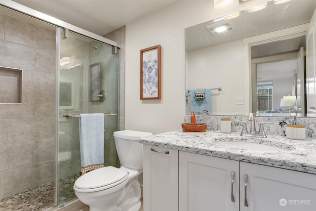 bathroom with walk in shower, vanity, and toilet