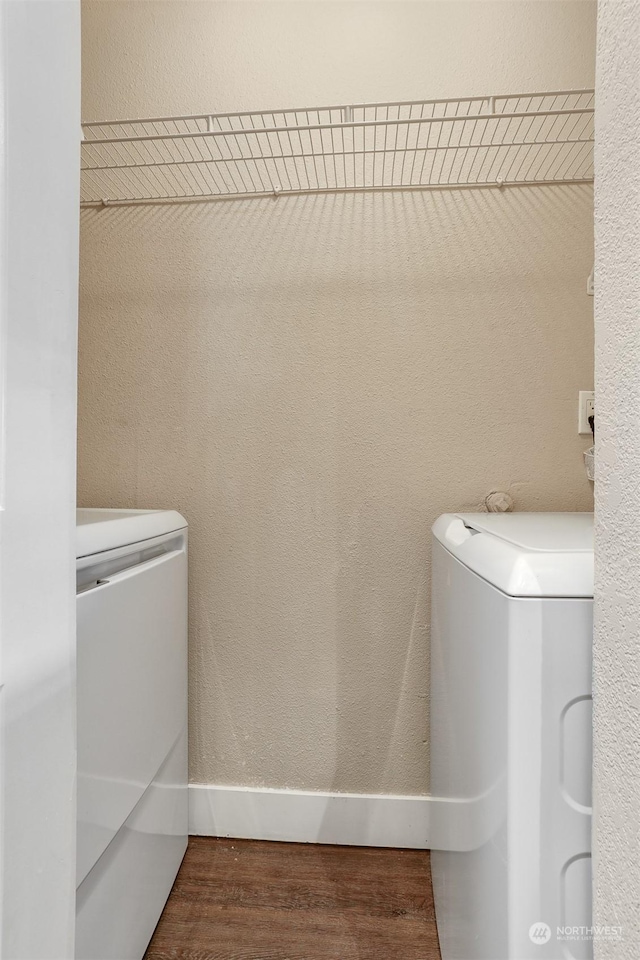 laundry area with dark hardwood / wood-style flooring and washing machine and dryer