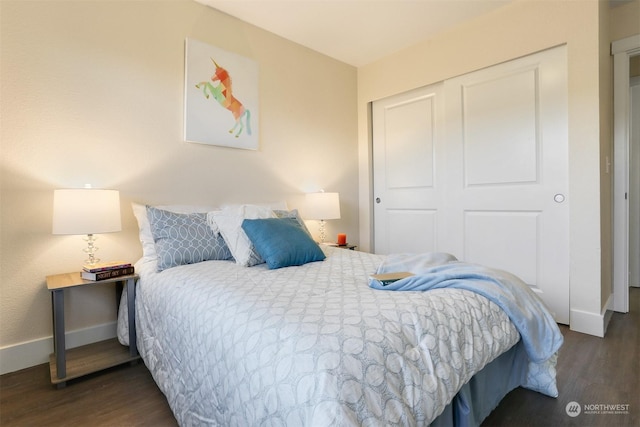 bedroom with dark hardwood / wood-style flooring and a closet