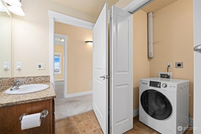 washroom featuring washer / clothes dryer, sink, and light carpet