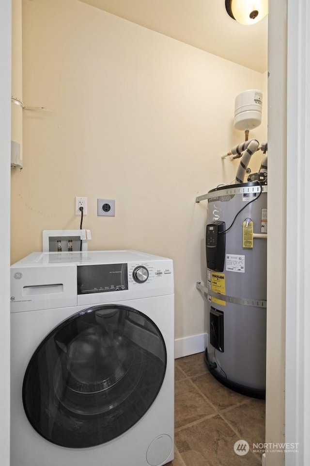 laundry room featuring dark tile patterned flooring, washer / dryer, and water heater