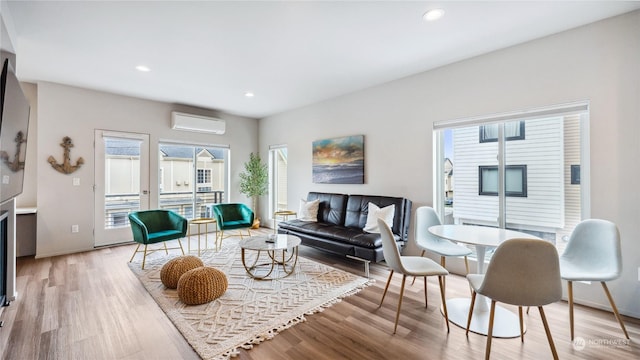 living room featuring a wall mounted AC and light hardwood / wood-style floors