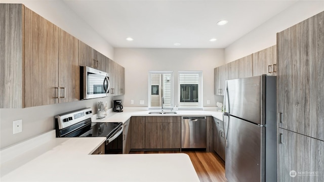 kitchen featuring stainless steel appliances, sink, and light hardwood / wood-style floors