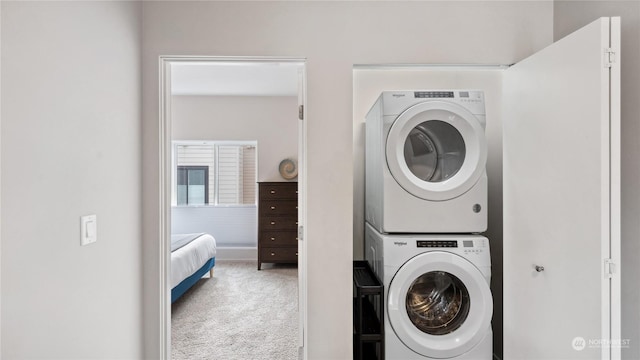 washroom featuring stacked washer / dryer and carpet