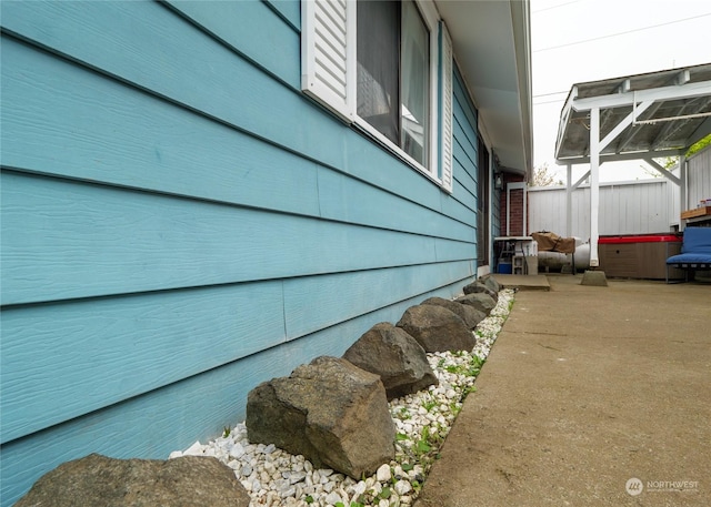 view of home's exterior featuring glass enclosure and a patio