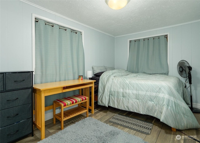 bedroom with hardwood / wood-style flooring, ornamental molding, and a textured ceiling