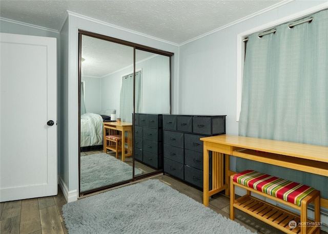 bedroom featuring a closet, ornamental molding, dark hardwood / wood-style floors, and a textured ceiling