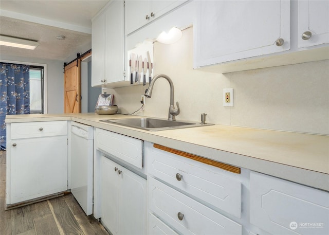 kitchen with sink, white cabinetry, white dishwasher, dark hardwood / wood-style flooring, and a barn door