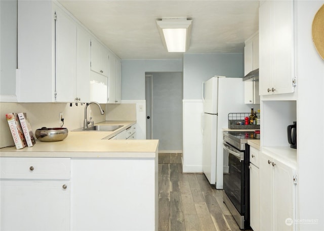 kitchen with hardwood / wood-style floors, white cabinetry, sink, kitchen peninsula, and stainless steel electric range