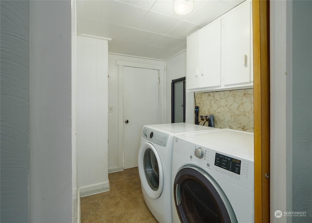 laundry area with cabinets, independent washer and dryer, and light tile patterned floors