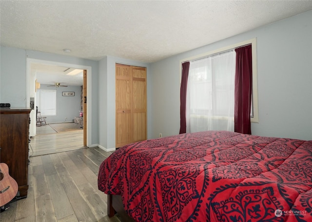 bedroom featuring a closet, wood-type flooring, and a textured ceiling