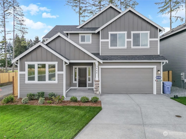 view of front of property with roof with shingles, an attached garage, board and batten siding, a front yard, and driveway