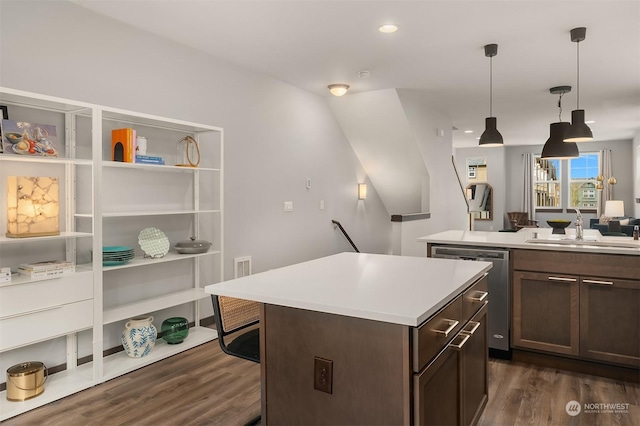 kitchen featuring dark hardwood / wood-style floors, pendant lighting, dishwasher, sink, and a center island