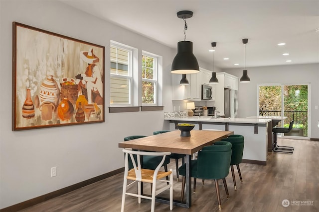 dining area featuring plenty of natural light and dark hardwood / wood-style floors