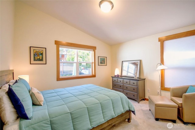 bedroom with vaulted ceiling and light colored carpet