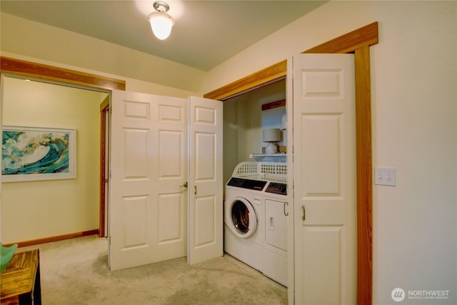 laundry area featuring baseboards, light colored carpet, laundry area, and washing machine and clothes dryer