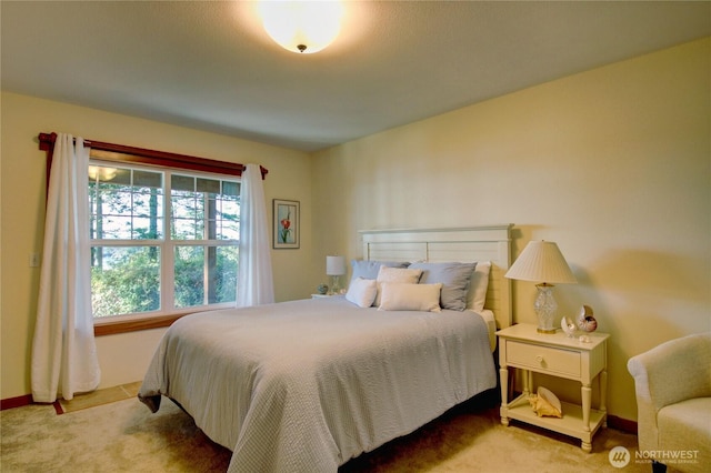 bedroom featuring light colored carpet and baseboards