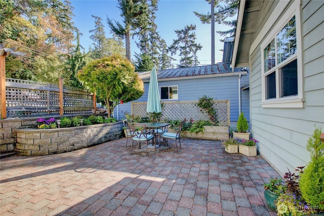 view of patio featuring outdoor dining space and fence