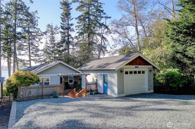 view of front of home featuring gravel driveway, an outbuilding, a garage, and a wooden deck