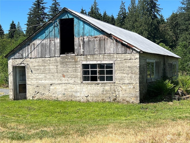 view of side of property featuring a barn, a yard, and an outdoor structure