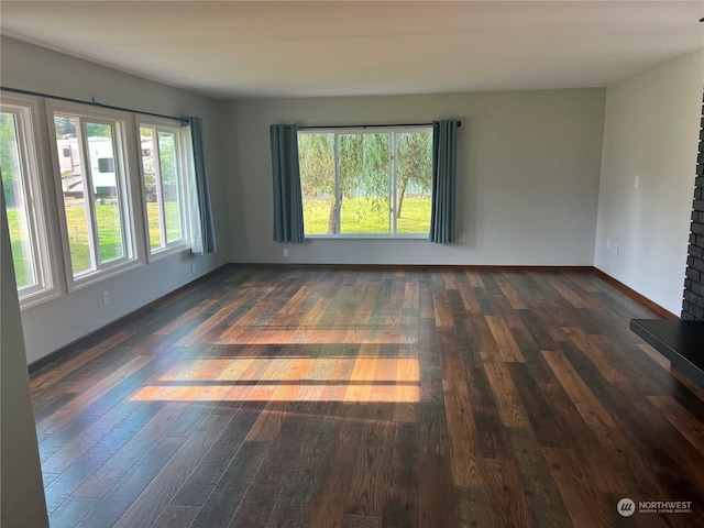 empty room featuring dark wood-type flooring and baseboards