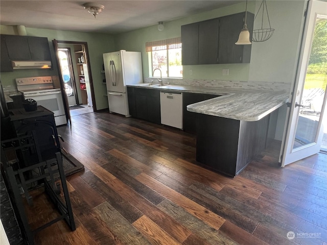 kitchen featuring light countertops, white appliances, a peninsula, under cabinet range hood, and dark wood finished floors