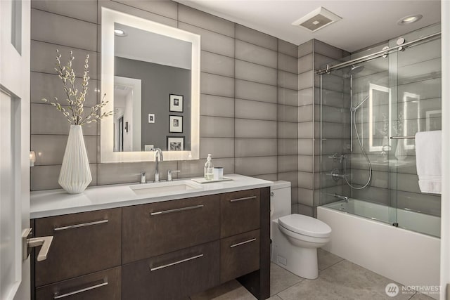 full bathroom featuring vanity, visible vents, toilet, enclosed tub / shower combo, and tile patterned floors