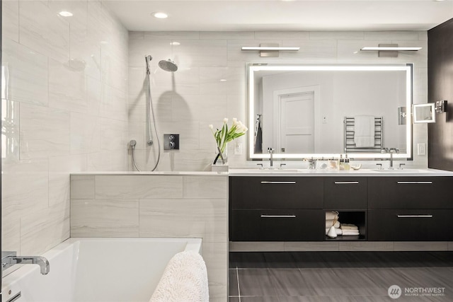 bathroom featuring a sink, tiled shower / bath combo, and double vanity