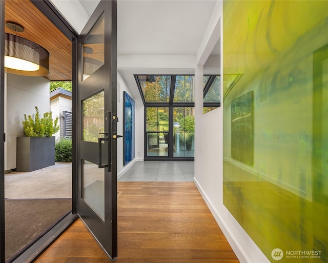 doorway to outside with baseboards and wood finished floors