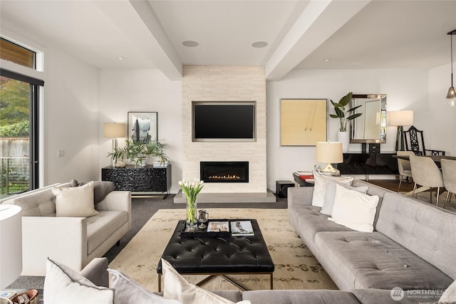 living room with a stone fireplace and carpet floors