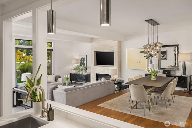 dining area with wood finished floors and a fireplace