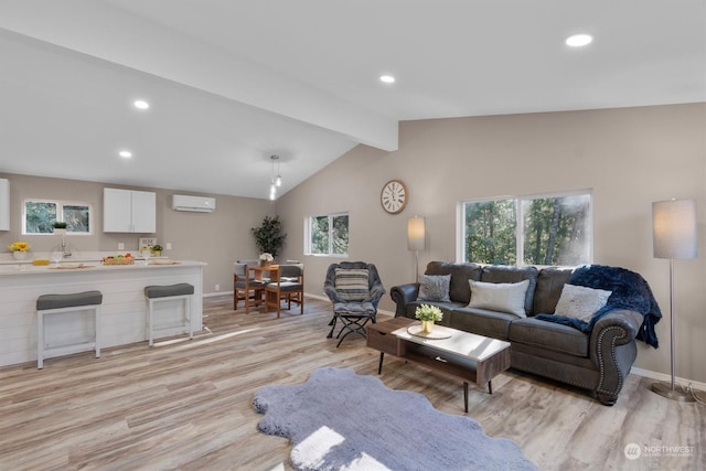 living room with light hardwood / wood-style flooring, lofted ceiling with beams, an AC wall unit, and plenty of natural light