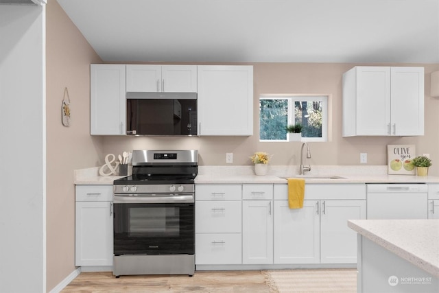 kitchen featuring dishwasher, white cabinetry, sink, light hardwood / wood-style floors, and electric stove