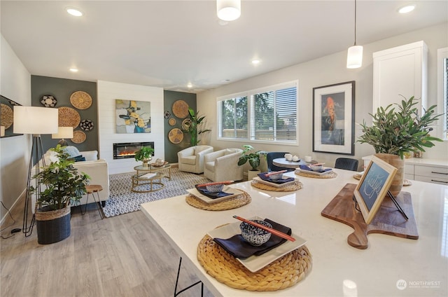 living room with a large fireplace and light hardwood / wood-style floors