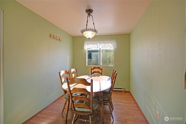 dining space featuring a baseboard radiator and light hardwood / wood-style flooring